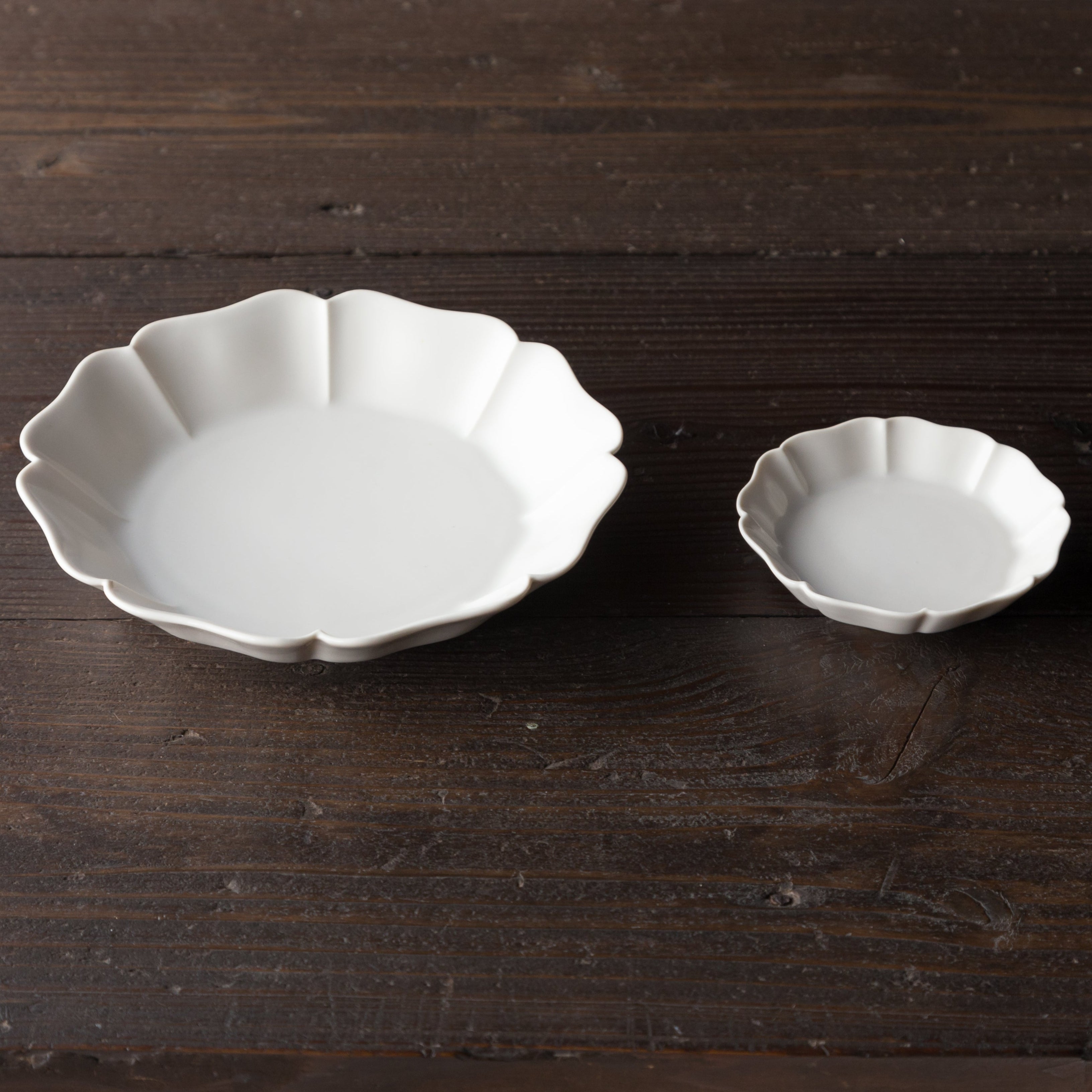Two white ceramic dishes on a dark wooden surface