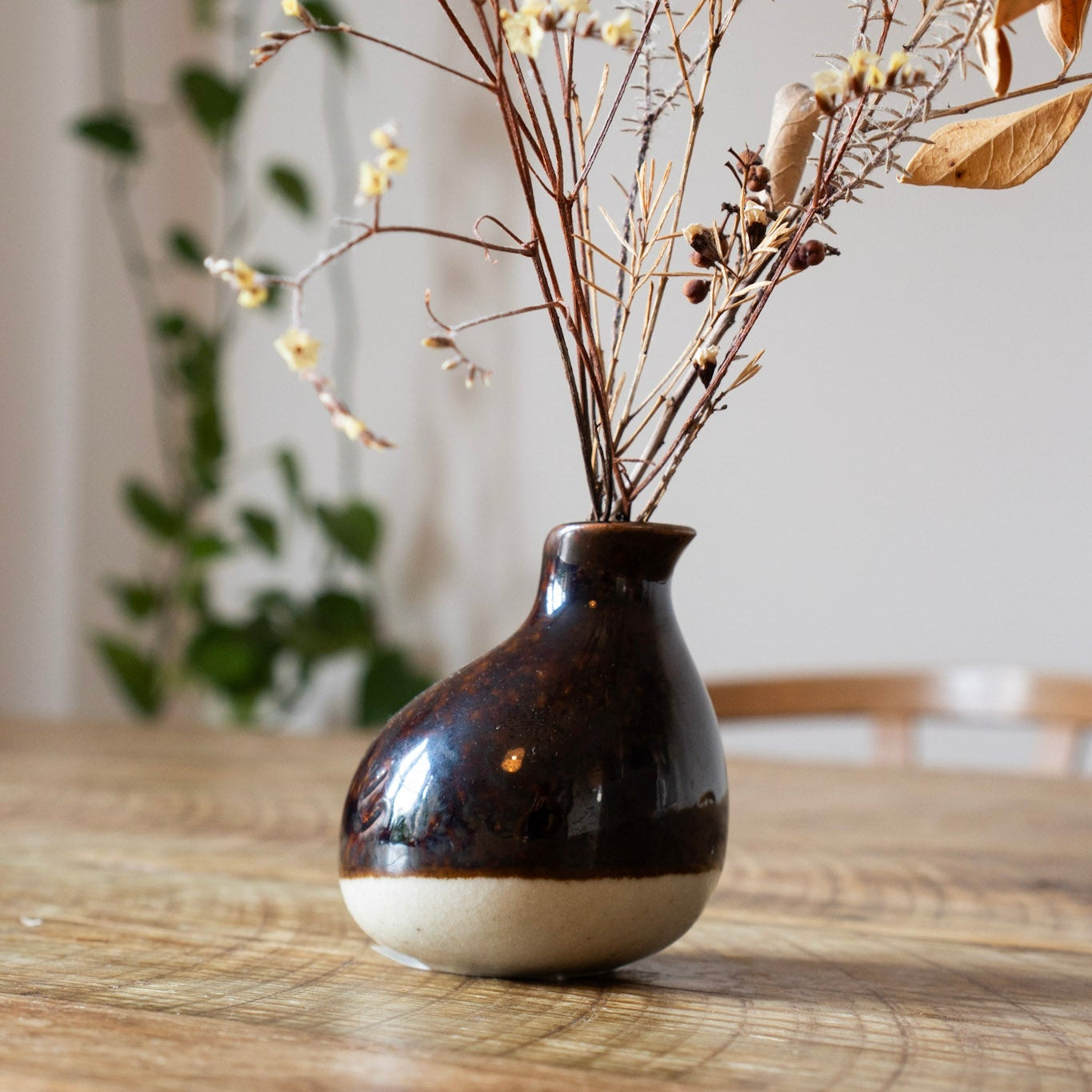 Black and white vase with dried flowers on a wooden table