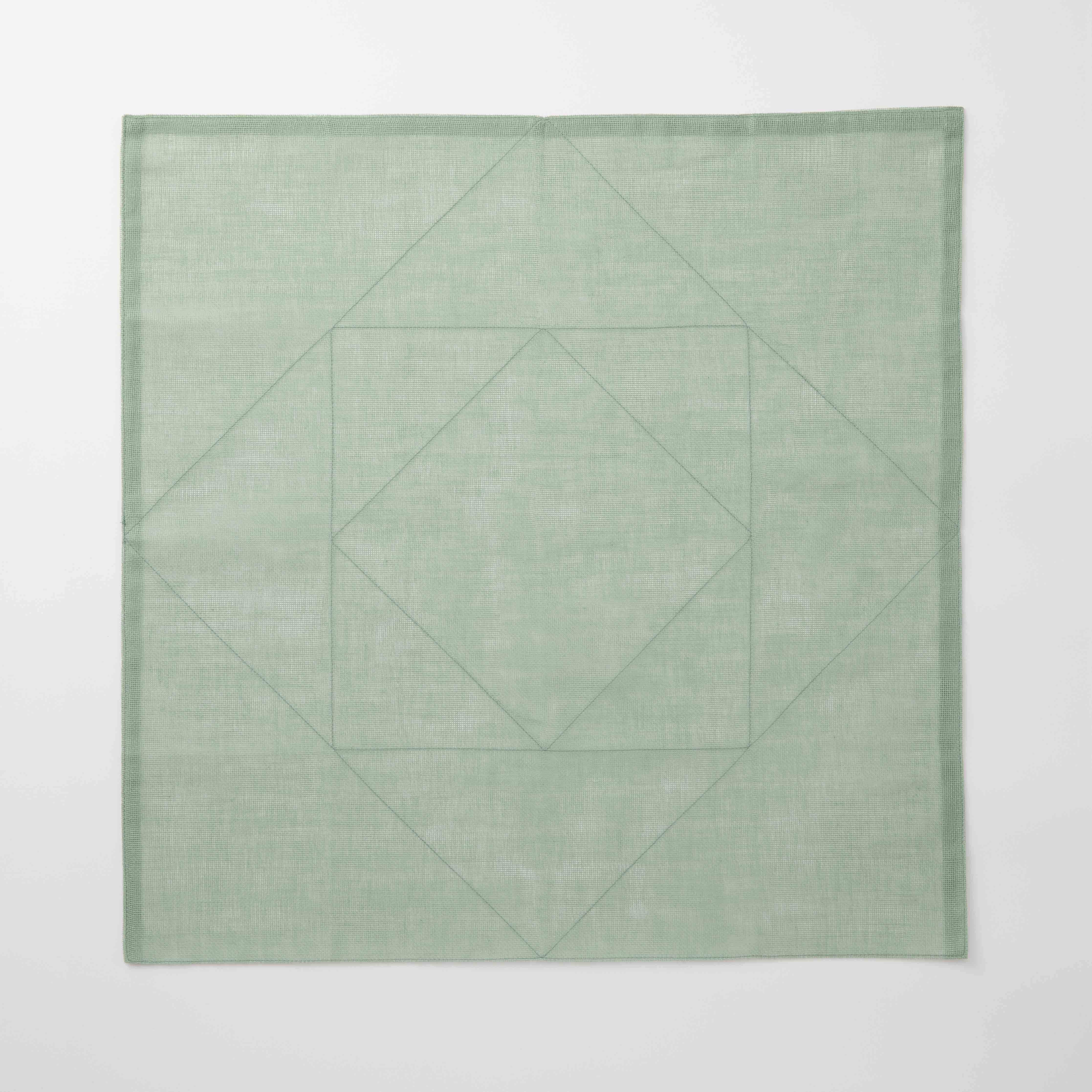 Green geometric patterned tea towel on a white background