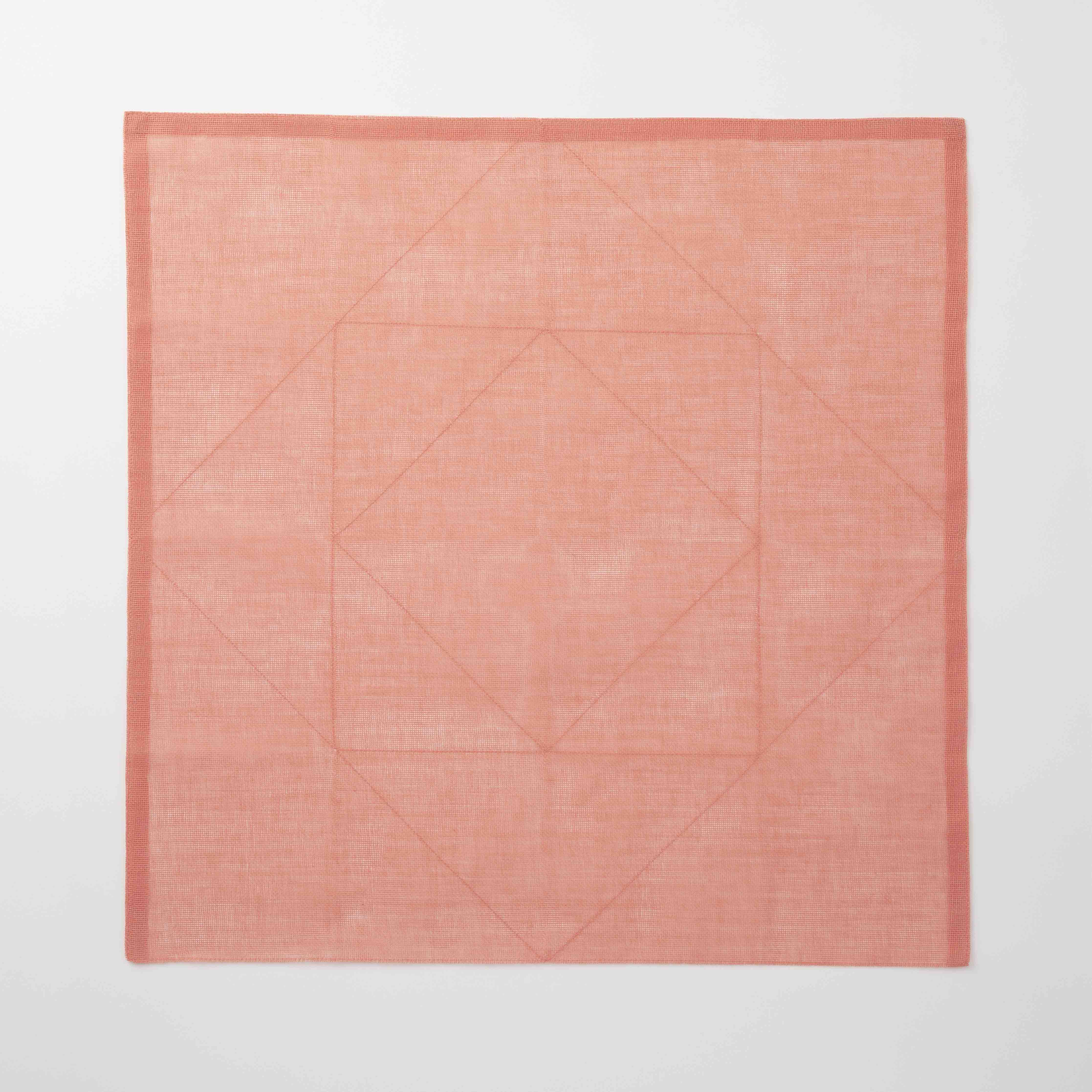 Coral tea towel with a geometric pattern on a white background
