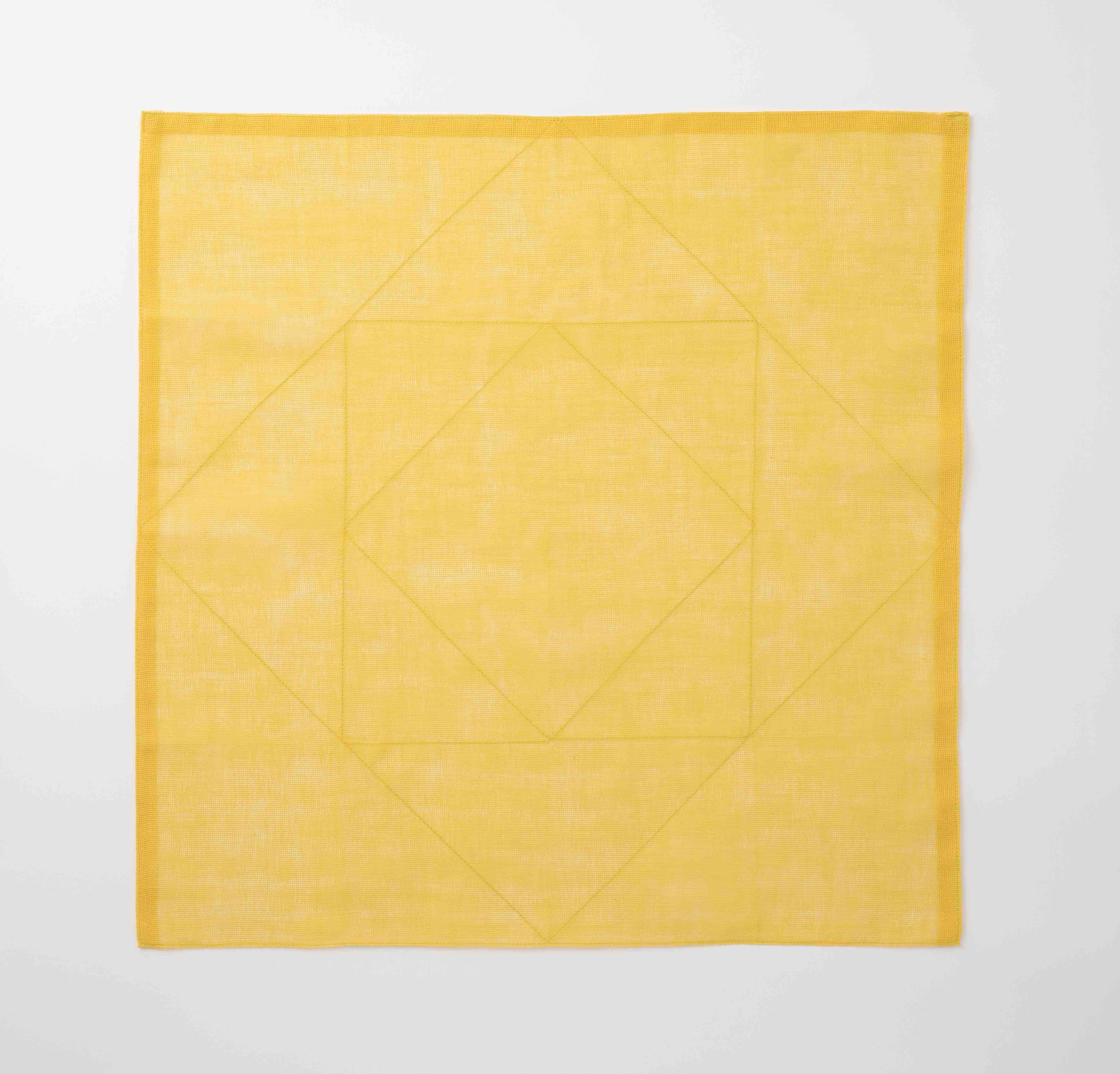 Yellow tea towel with a diamond pattern on a white background