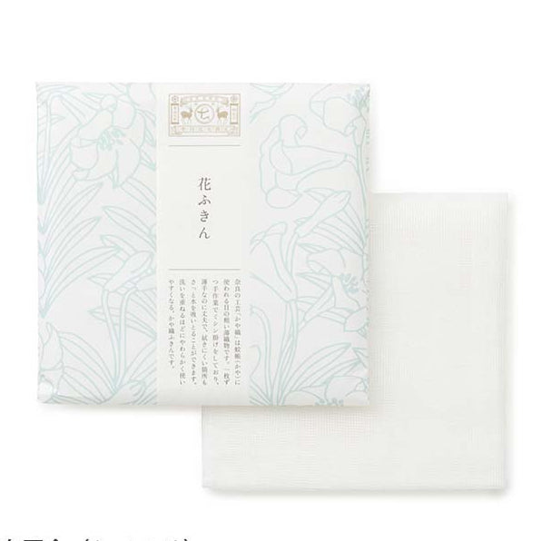 White tea towel packed in floral design wrapping paper on a white background