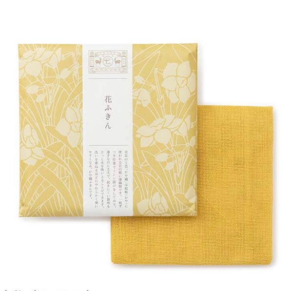 Yellow tea towel packed in floral design wrapping paper on a white background