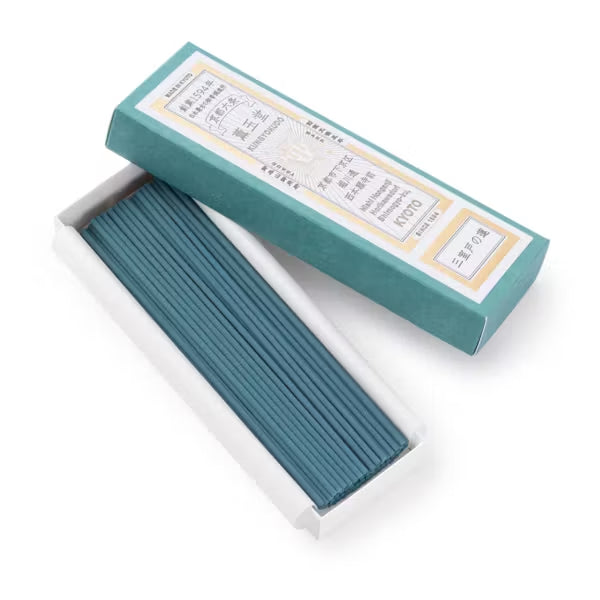 Teal incense sticks in a box on a white background