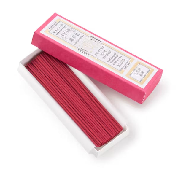 Red incense sticks in a pink box on a white background