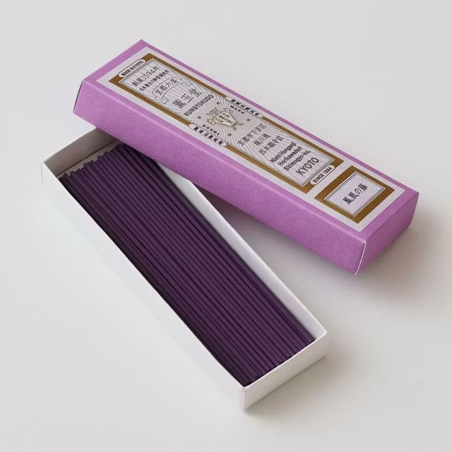 Purple incense sticks in an open box with a purple lid on a white background