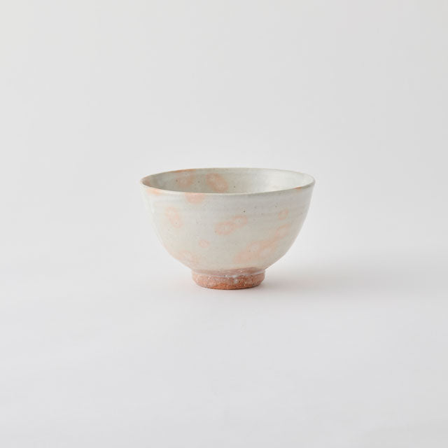 Ceramic bowl with a speckled pattern on a light gray background
