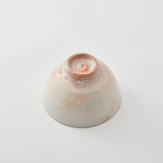 Ceramic bowl with speckled design on a light gray background