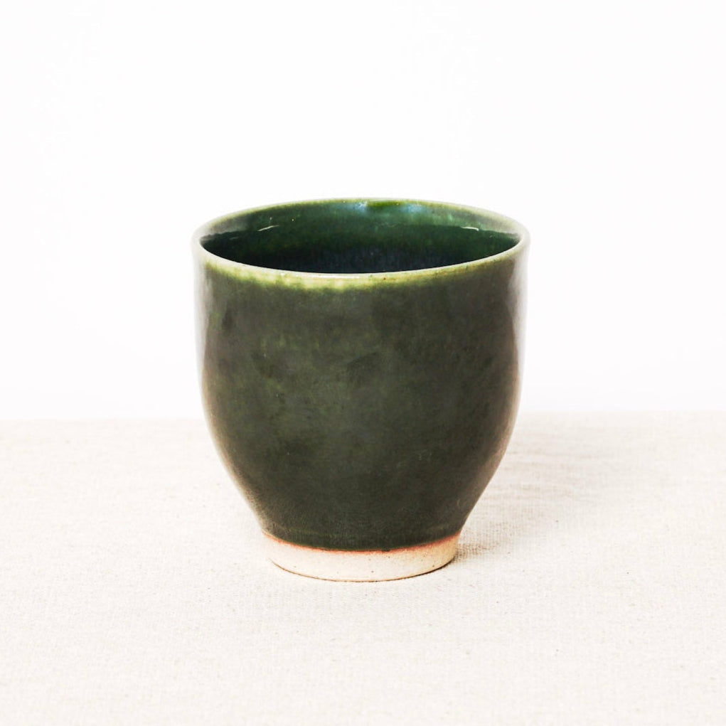 Green ceramic cup on a white background