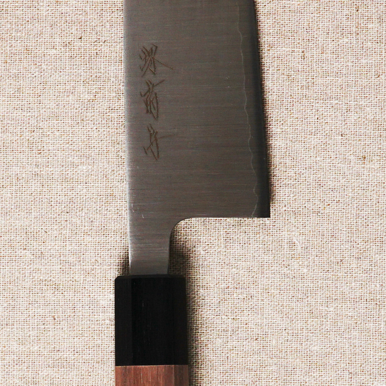 Japanese knife with wooden handle on a textured beige background