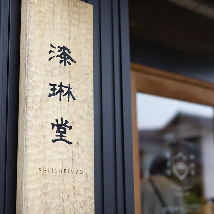 Traditional Japanese door with wooden frame and 'SHITSURINDO' branding.