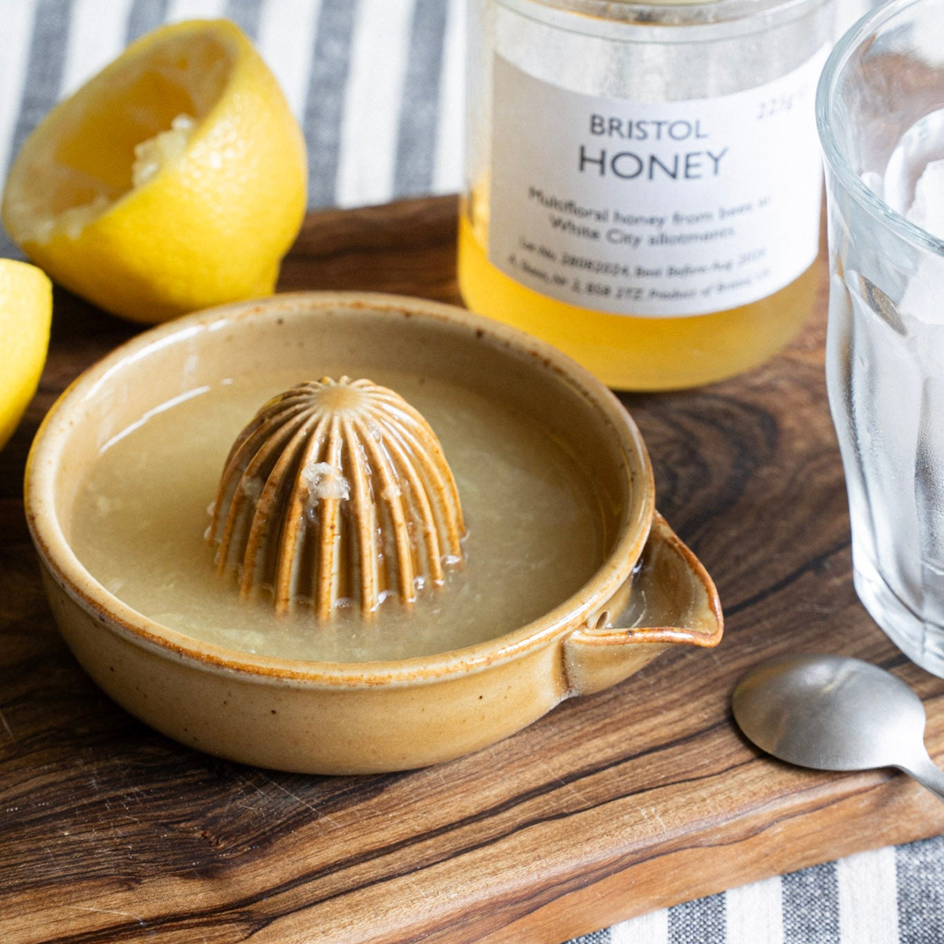 Ceramic lemon squuezer with Bristol Honey jar on a wooden board
