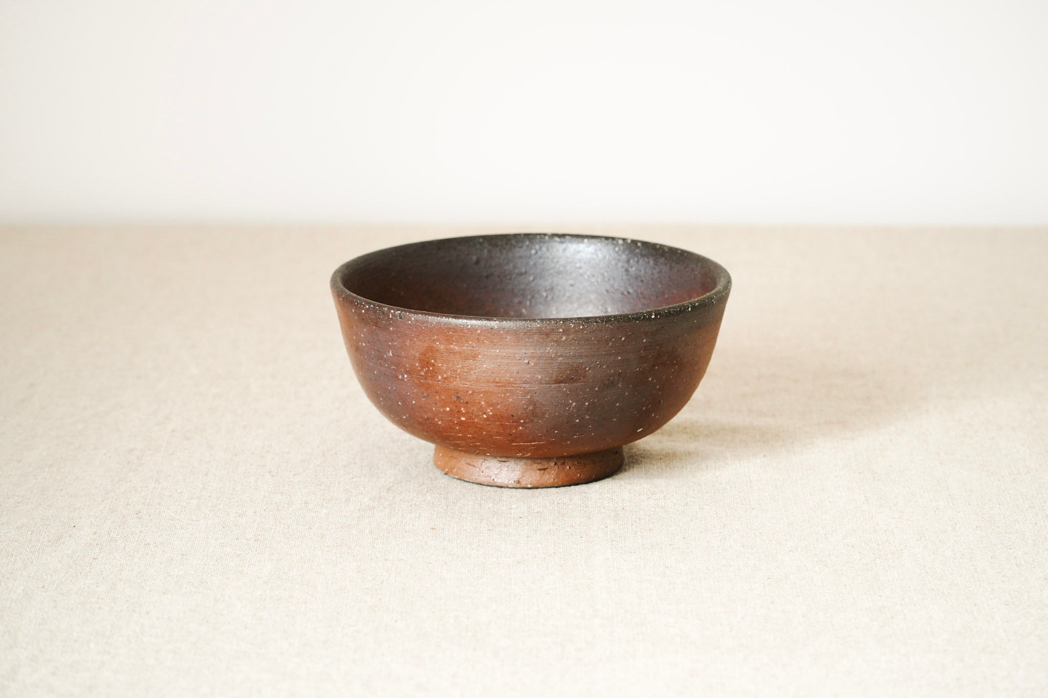 Brown Bizen ceramic bowl on a beige background
