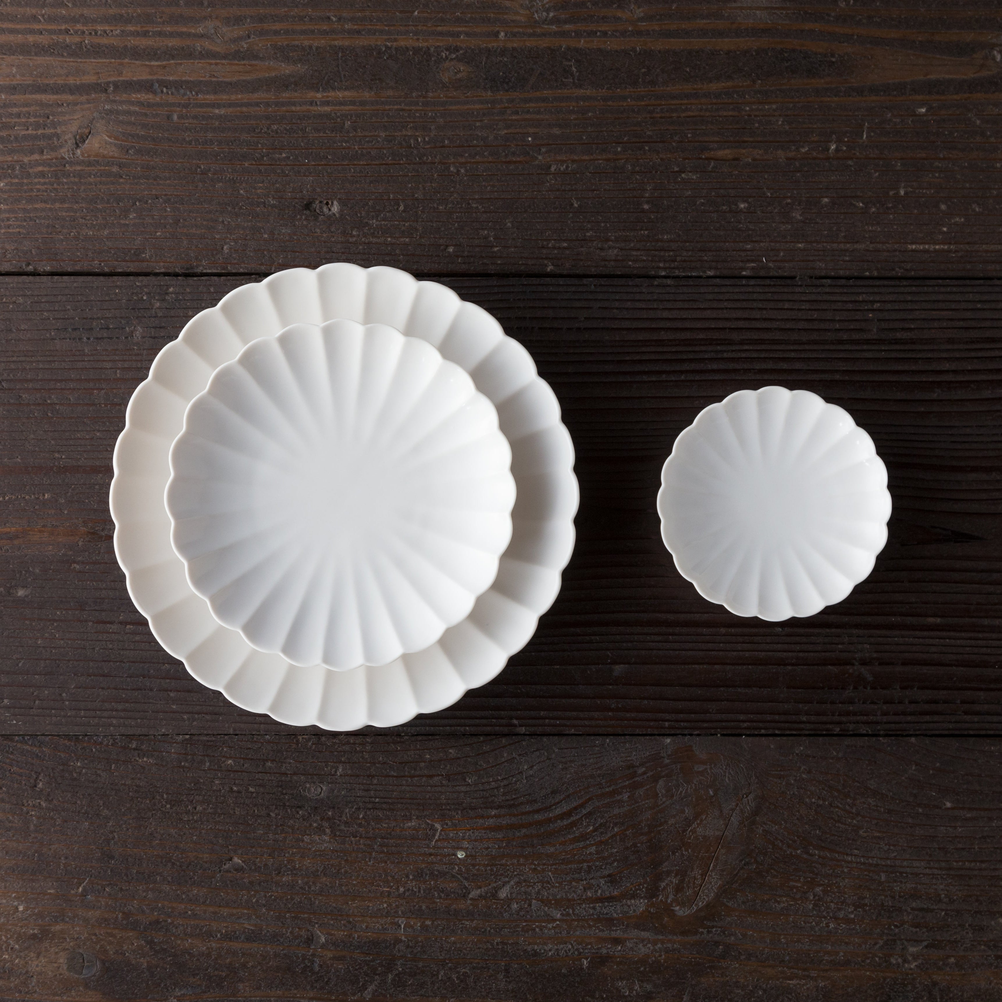 Two white ceramic plates on a dark wooden surface
