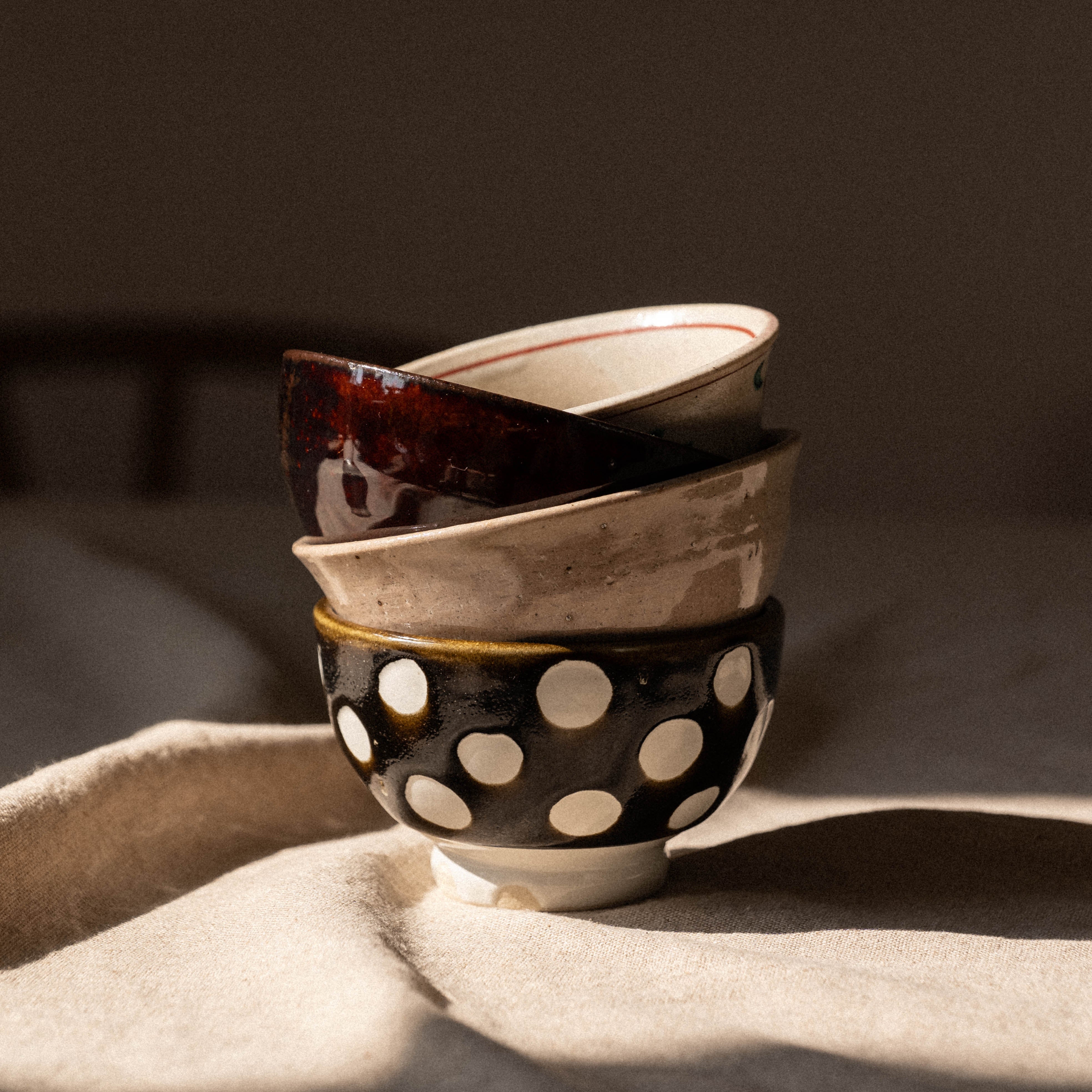 Stack of ceramic bowls with different designs on a textured surface