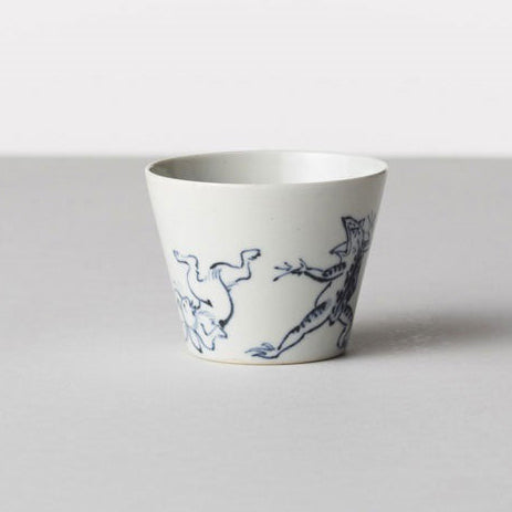 White ceramic cup with blue animal illustrations on a light gray background