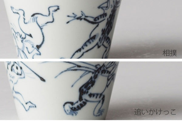 Ceramic cup with blue animal illustrations on a white background