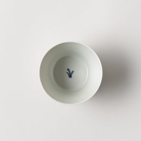 White ceramic bowl with a blue design on a light gray background
