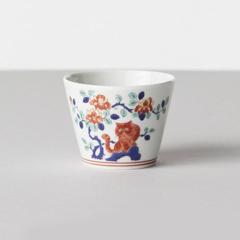 Ceramic cup with floral and animal design on a gray background