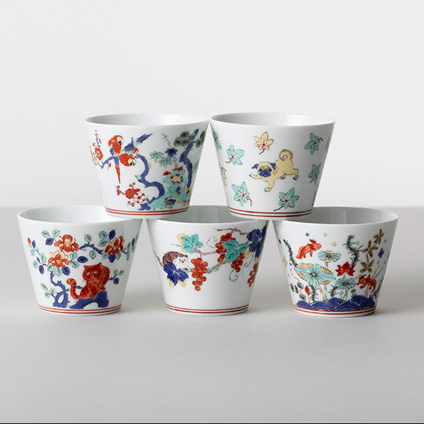 Five ceramic cups with colorful floral and animal designs on a white background