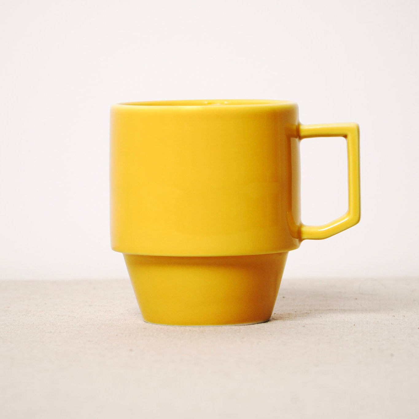 Yellow mug on a light beige background
