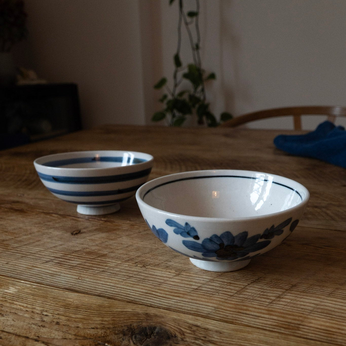 Two ceramic bowls with blue floral patterns on a wooden table.