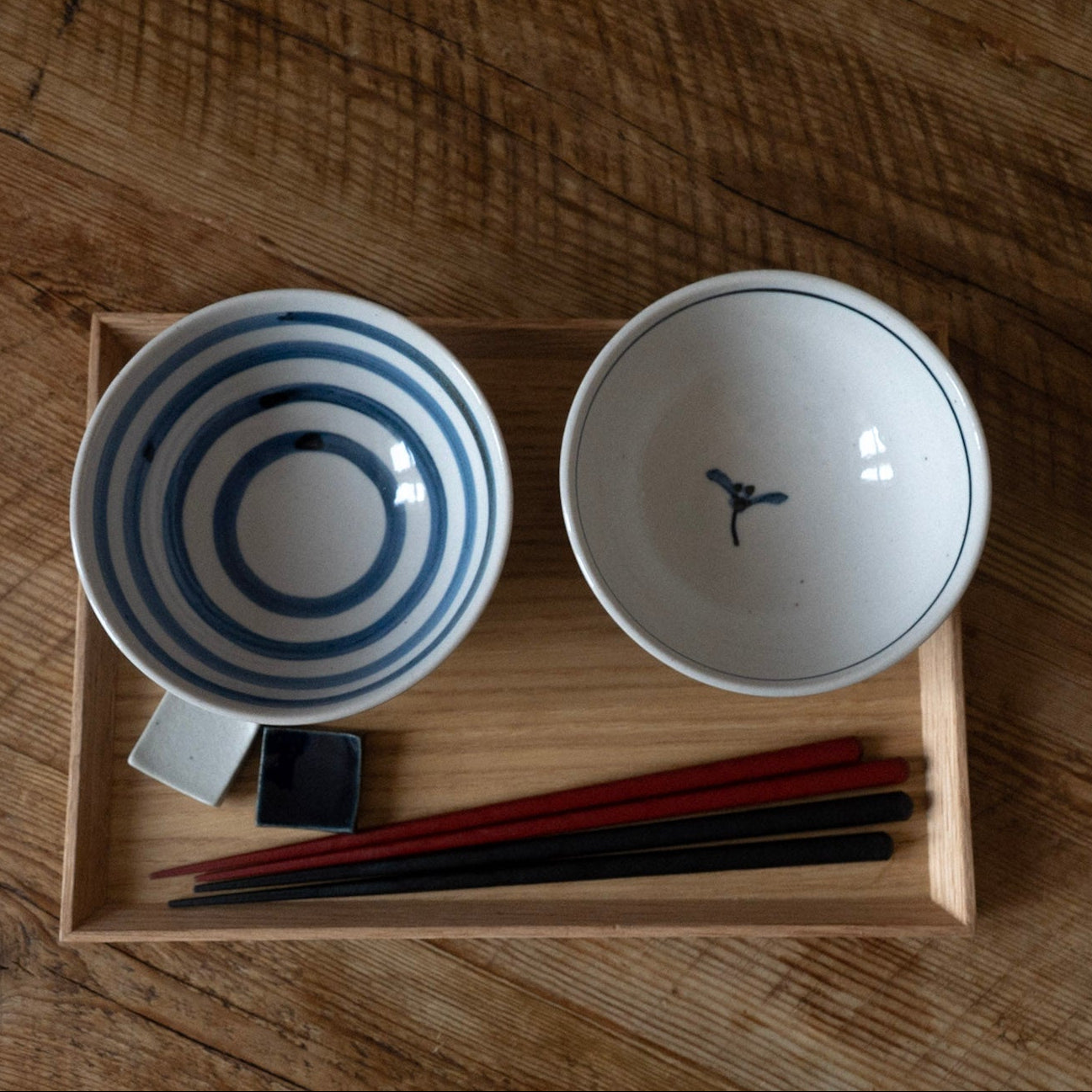 Two ceramic bowls with blue and white patterns on a wooden surface.