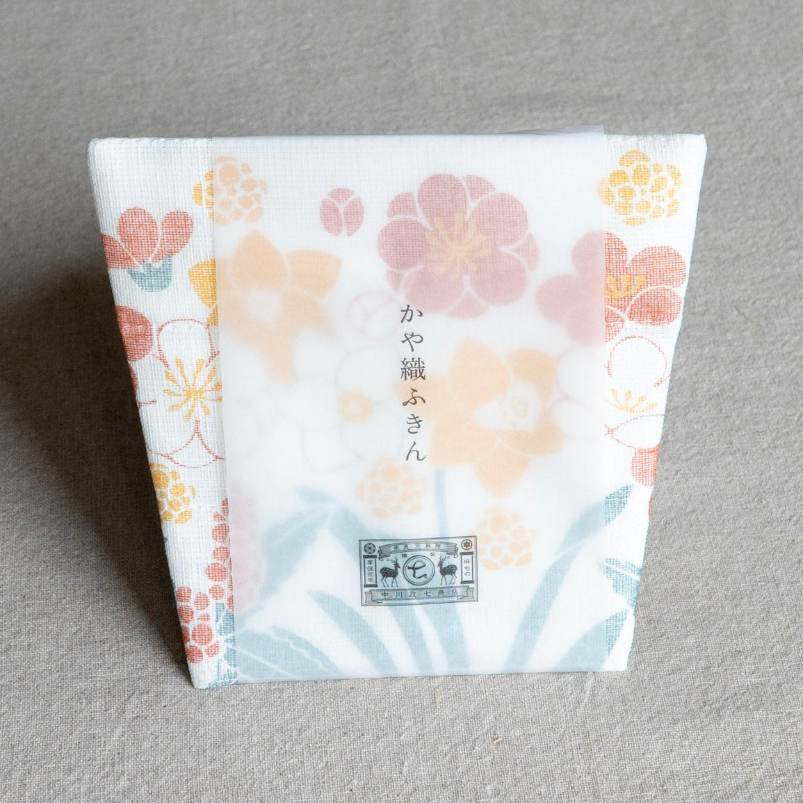 Folded dish cloth with flower bouquet design on a gray background