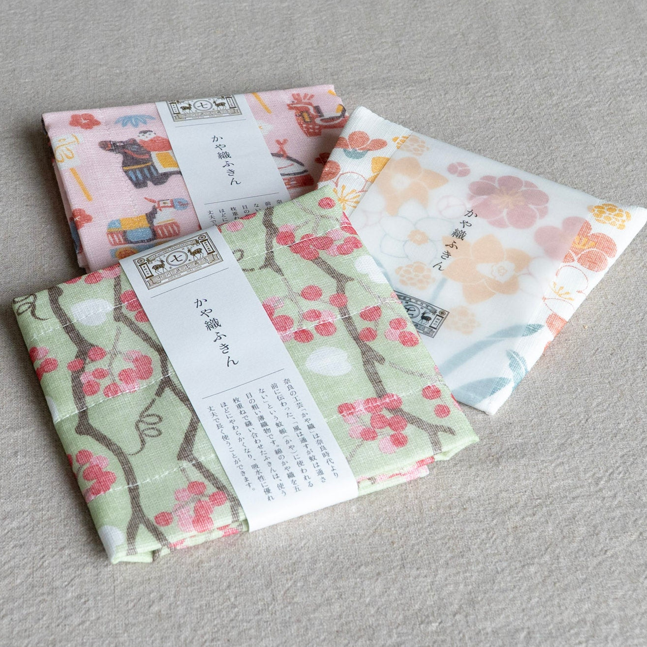 Three floral-patterned dish cloths on a gray surface