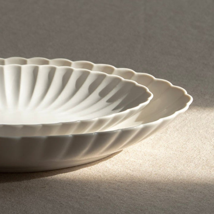White ceramic bowl on a light gray surface with a blurred background