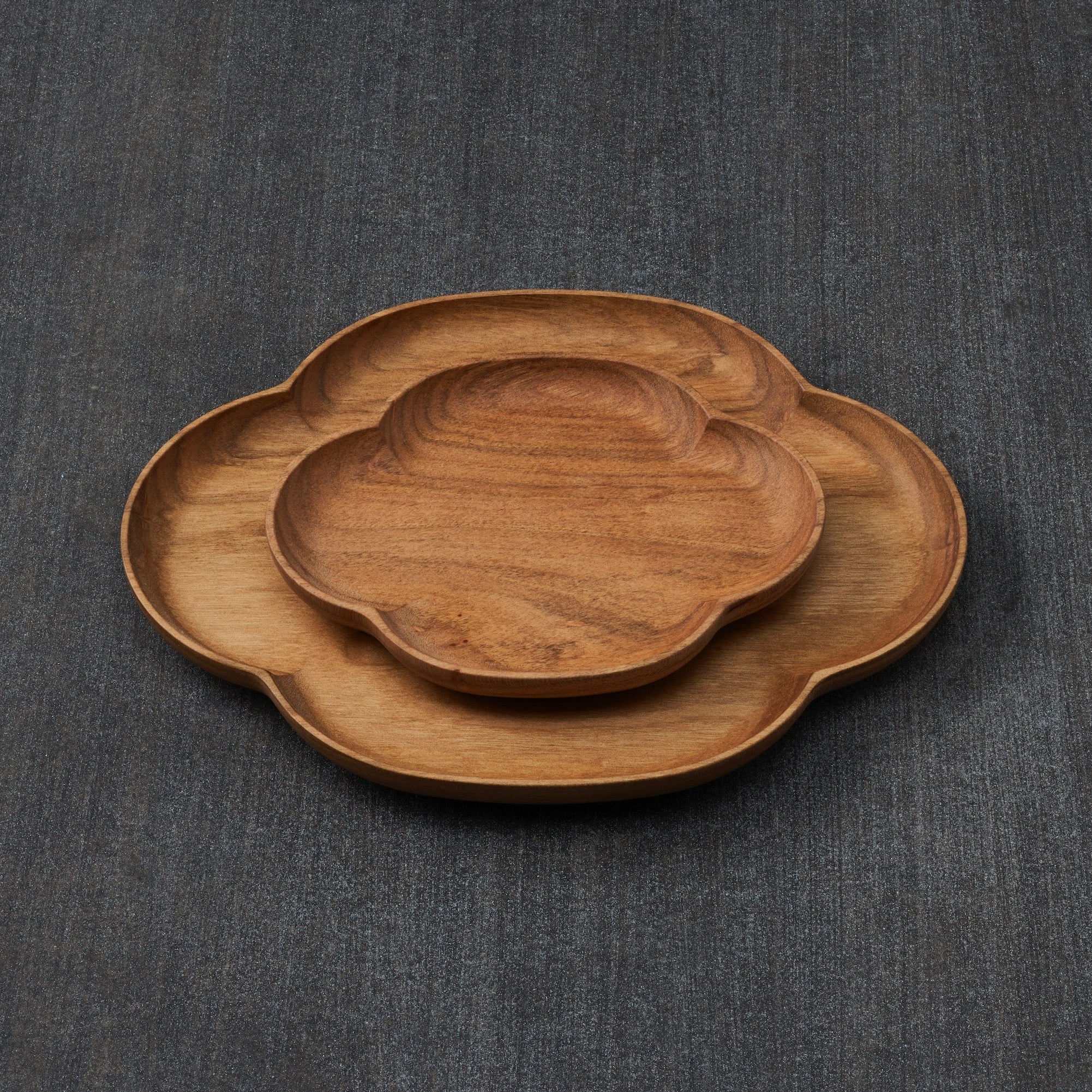 Two wooden trays on a dark gray fabric background