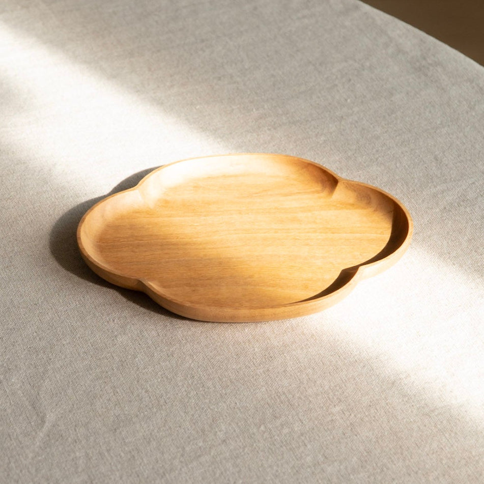 Wooden coaster on a textured white surface with soft shadows