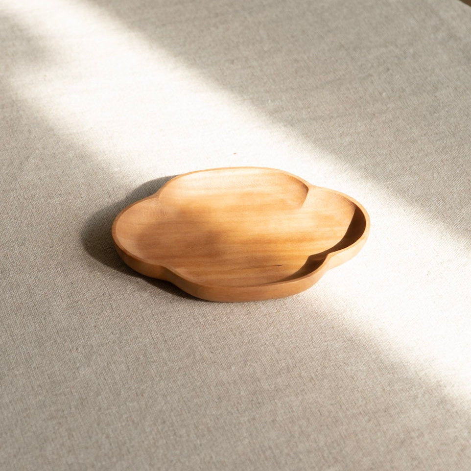 Wooden bowl on a textured surface with soft shadows