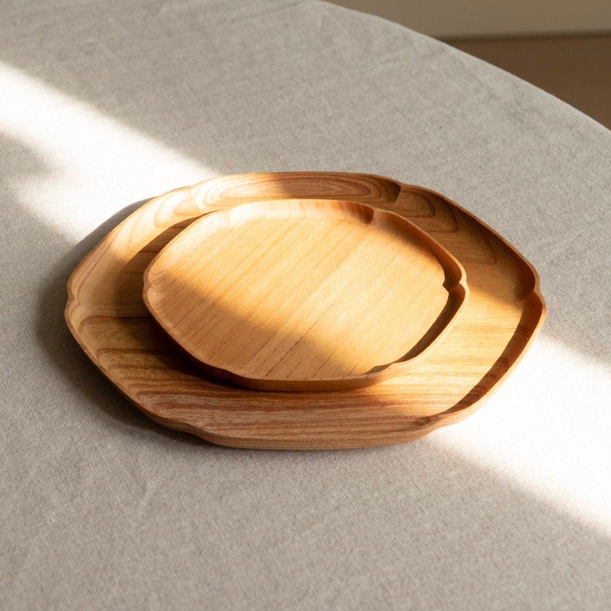 Wooden tray on a light gray surface with soft shadows