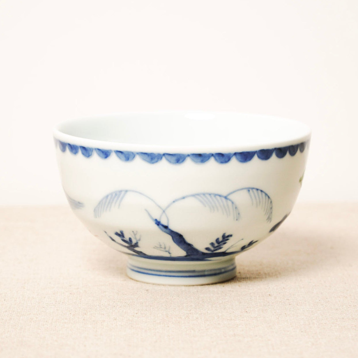 White ceramic bowl with blue floral patterns on a beige surface