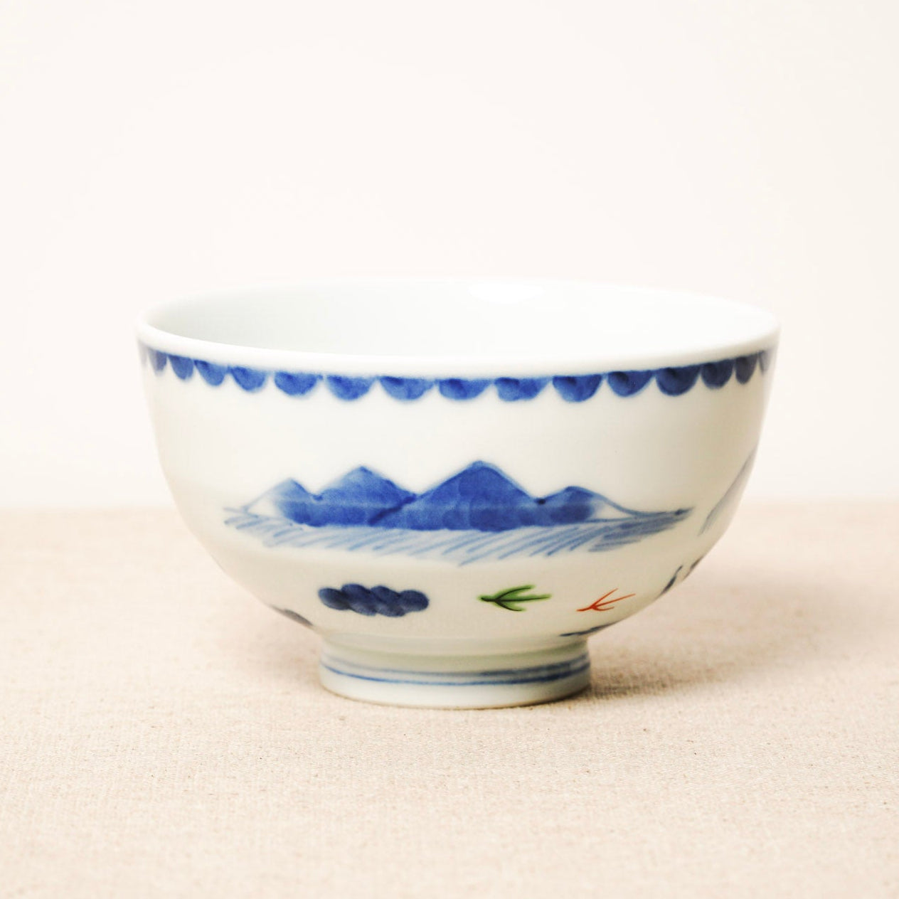 Ceramic bowl with blue and white design on a beige surface