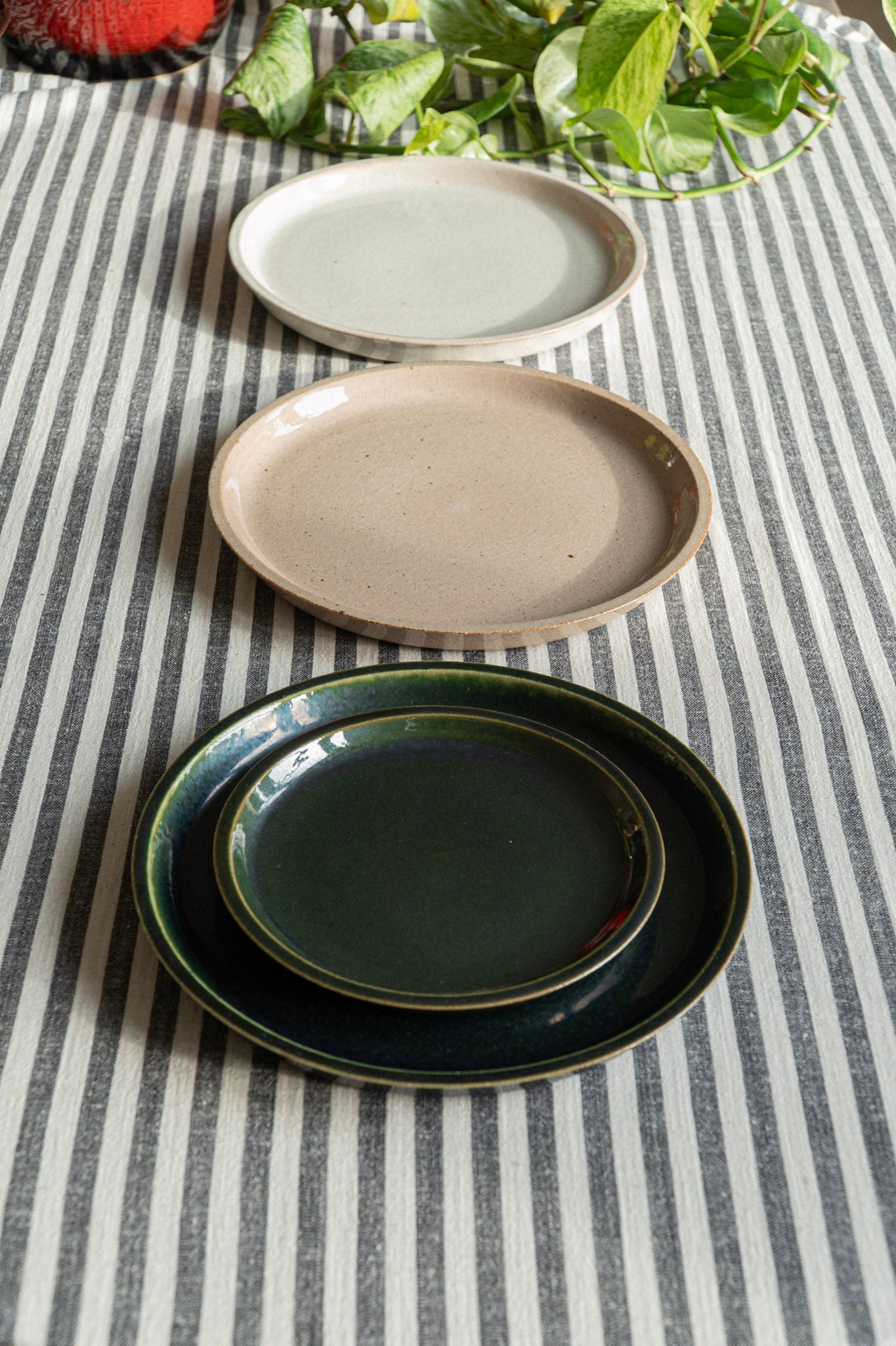 Set of ceramic plates in different colors on a striped tablecloth