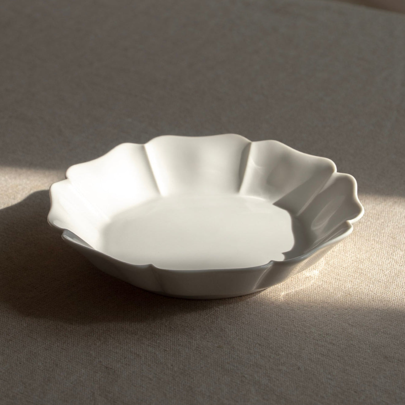 White ceramic dish on a textured surface with soft shadows