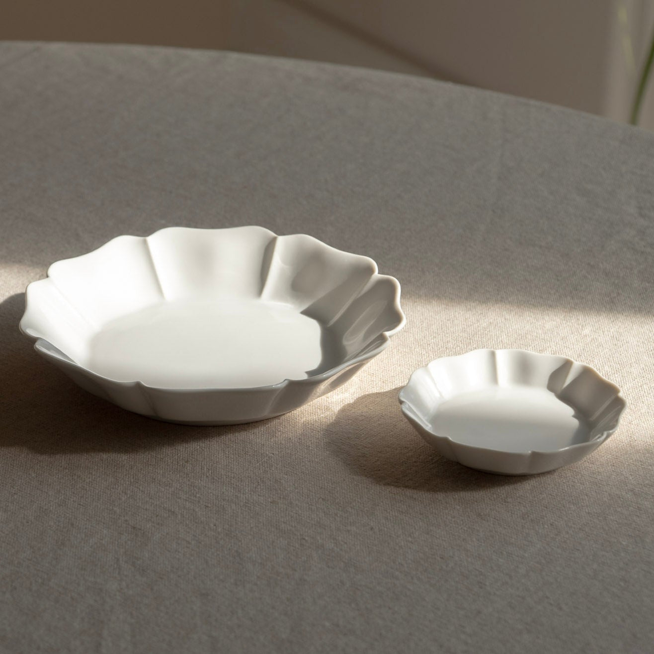 Two white ceramic bowls on a gray surface with a soft focus background