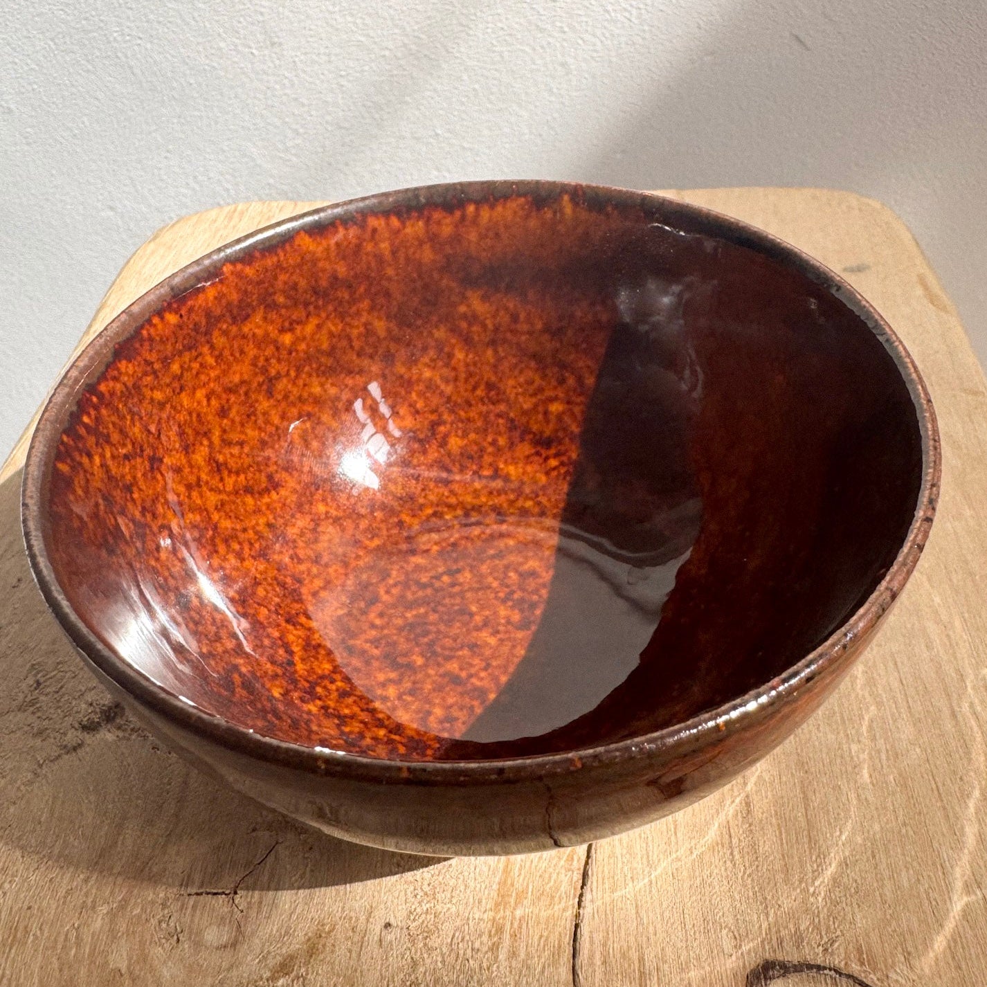 Brown  Seto ware ceramic bowl by Nakagawa on a wooden surface .