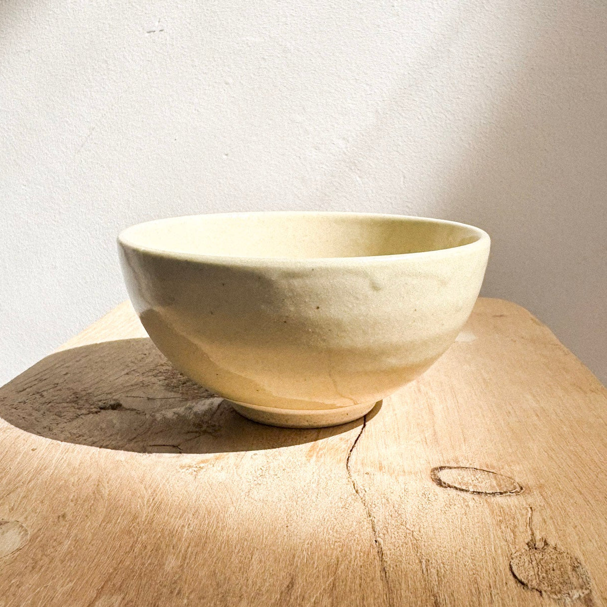 Light yellow seto ware ceramic bowl by Nakagawa on a wooden surface.