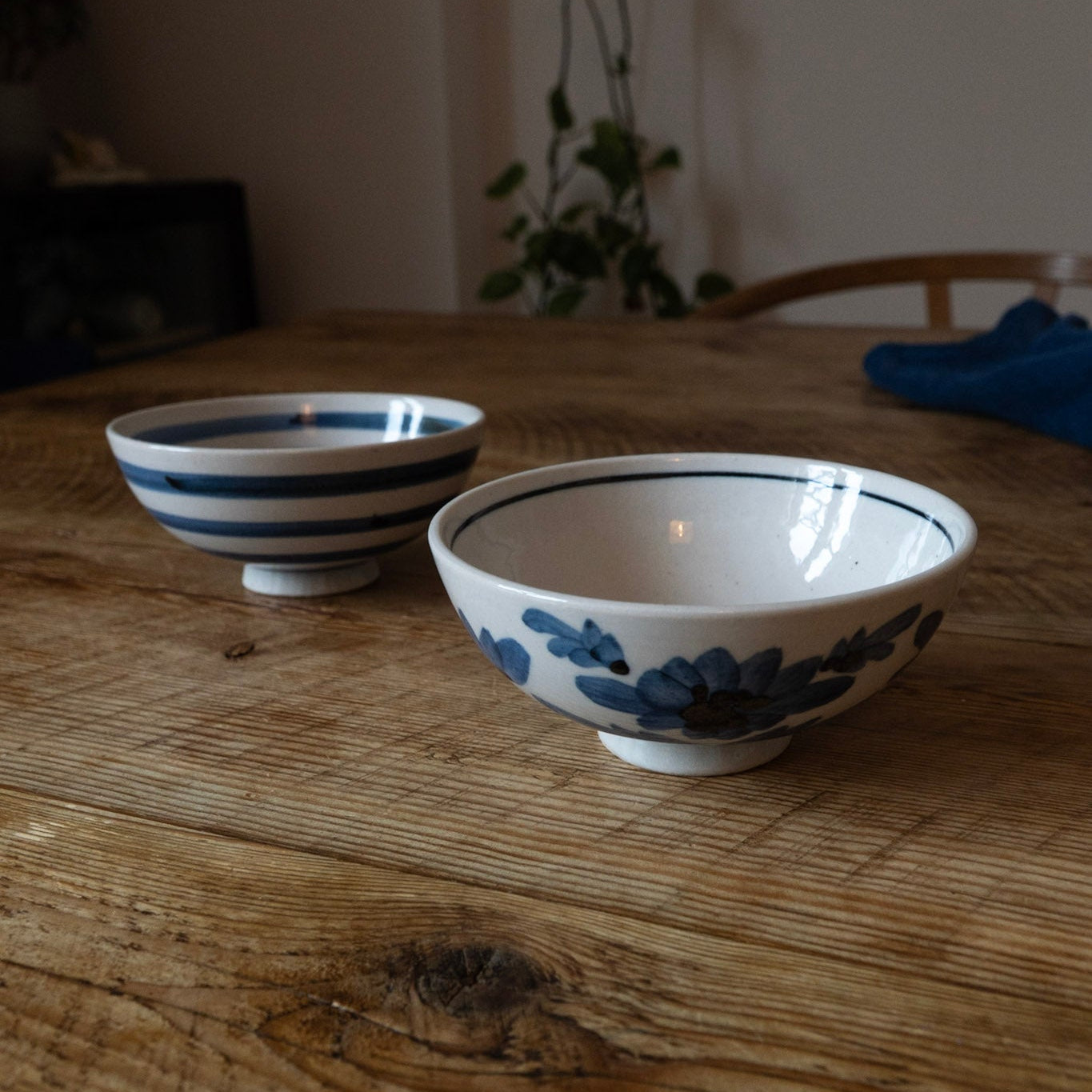 Two ceramic bowls with blue floral patterns on a wooden table.
