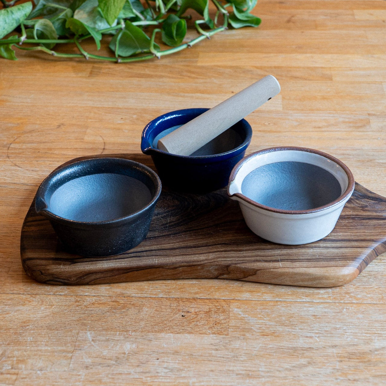 Set of ceramic bowls and a wooden ladle on a wooden surface